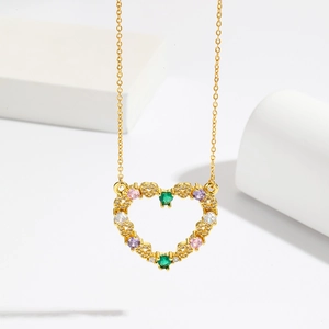 Gold hollow heart necklace featuring colorful emerald-cut zirconia on white pedestal
