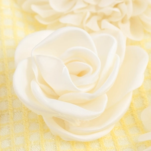 Elegante fiore in raso 3D bianco su una gonna in tweed giallo per uno stile chic e dolce