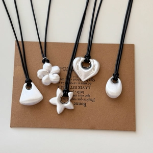 Matte silver pendant necklaces with heart, flower, and star shapes on black cords