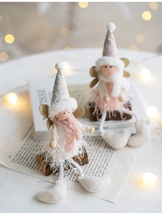 Detail of Christmas angel plush dolls with sequined hats and fur collars in cozy setting