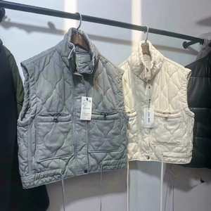 Grey quilted puffer vest with stand collar and large pockets shown on a hanger