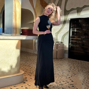 Detail of elegant black sleeveless evening dress with pleated texture and shimmering fabric