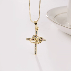Collana con croce dorata con cuori intrecciati e pietre di zircone colorate su sfondo bianco