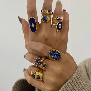 Detailed view of vintage gold ring set with blue stones and evil eye motifs on fingers