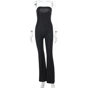 Close-up of black strapless jumpsuit featuring white polka dot pattern and slim fit design