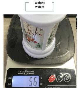 White Christmas lantern detail showing 56g weight on a digital scale for shipping