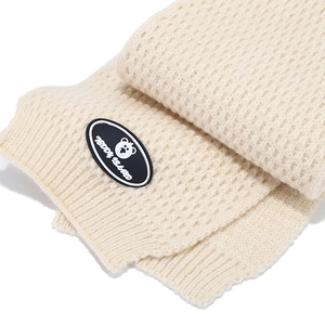 Close-up of beige knitted winter set with Teddy Island bear patch and soft texture
