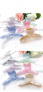 Detail of fishtail-shaped hair claws with pearlescent finish in multiple colors