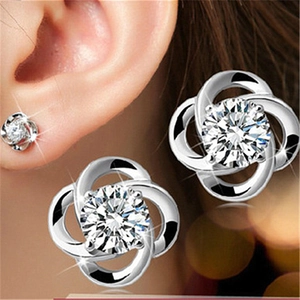 Macro detail of silver flower stud earrings featuring brilliant cubic zirconia petals
