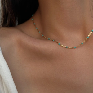 Close-up of gold 18k plated necklace featuring turquoise beads on a delicate chain