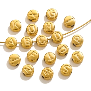 Golden stainless steel round alphabet beads for DIY jewelry making on white background