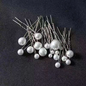 Macro shot of 18 silver U-shaped hair pins with glossy faux pearls for bridal styling
