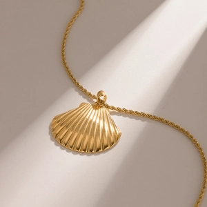 Vue détaillée du pendentif coquillage plaqué or 18k avec une chaîne torsadée