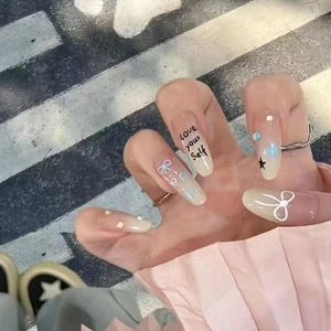 Long oval gradient press-on nails with white bows, blue dots and Love Yourself slogan