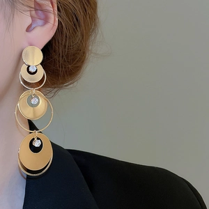 Detail shot of multi-layer gold circular drop earrings with sparkling zircon stones