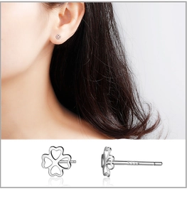 Macro shot of S999 sterling silver stud earrings featuring hollow four-leaf clover design
