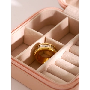 Polished wide gold titanium ring featuring three zircon stones on velvet