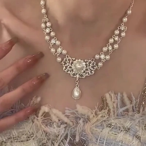 Detail of flower necklace with white pearls and crystals worn on neck for women