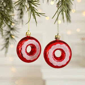 Red and pink donut Christmas tree ornaments with glitter finish on pine branch