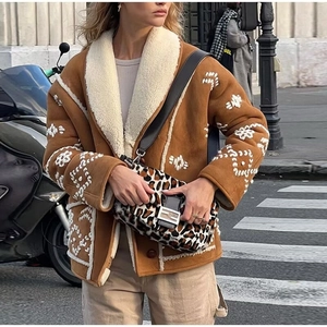 Detail of short brown jacket with white embroidery and soft faux shearling collar