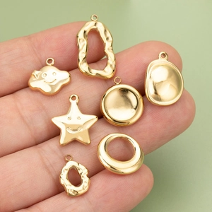 Golden stainless steel charm set featuring cloud star and geometric shapes held in hand
