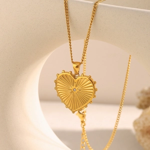Detail view of 18K gold plated heart pendant with radial texture and central diamond
