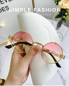 Macro shot of steampunk round metal sunglasses with pink-yellow gradient lenses and CE mark