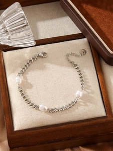 Detail of stainless steel pearl bracelet with lobster clasp and baroque pearls in a gift box