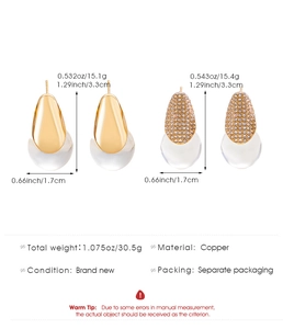 Detailed view of gold water drop earrings with clear resin charms and copper base specs