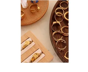 Detailed close-up of vintage gold rings with abstract faces and camera carvings on wood