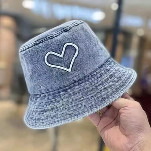 Light blue washed denim bucket hat featuring white heart embroidery detail