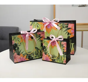 Three-size tropical floral gift bags set with gold rope handles and pink satin bows