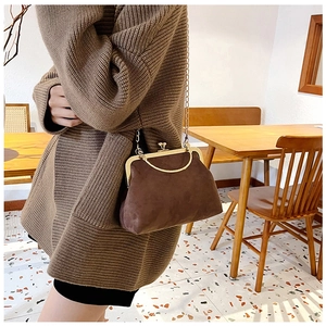 Gros plan détaillé du sac à main en daim marron vintage avec un fermoir en métal doré