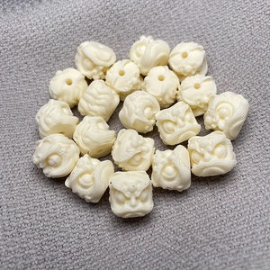 Detailed view of ivory-colored lion head carved beads for DIY bracelet jewelry making