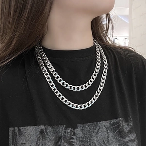 Close-up of double layered silver Cuban link necklace worn by a model in a street style