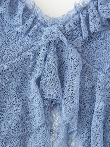 Gros plan détaillé de dentelle bleu clair avec textures fines et plis superposés