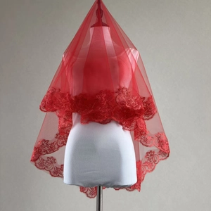 Detailed close-up of a long red bridal veil with exquisite floral lace embroidery on the edge