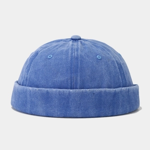Detail view of blue washed denim docker cap showing top button and ventilation eyelets