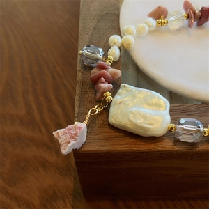 Detail of baroque pearl and rose stone bracelet with golden accents on display