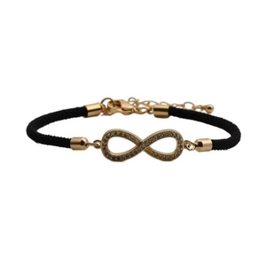 Detailed macro view of black braided rope bracelet with gold infinity diamond charm