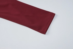 Dettaglio della manica dell'abito rosso vino con cuciture doppie rifinite e tessuto jersey