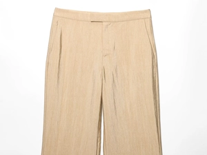 Detailopname van champagne zijden broek met verticale textuur en hoge tailleband