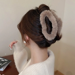 Macro detail of a plush brown shark hair clip for women used in an elegant bun hairstyle