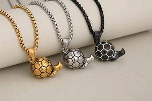 Close-up of soccer ball pendants with whistle detail in gold, silver, and black finishes