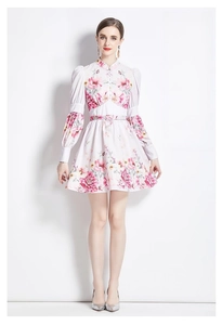 Détail de mini robe fleurie avec manches bouffantes, col officier et ceinture ajustée