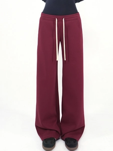 Detail view of burgundy wide-leg joggers featuring a contrasting cream drawstring waist
