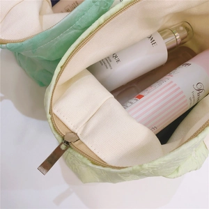 Detail showing the spacious interior of a mint green jacquard canvas makeup bag with lining