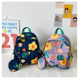 Detail view of two colorful floral kids backpacks in navy and lilac with round coin pouches
