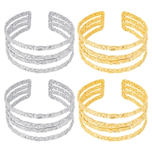 Detailed view of layered hollow open bangles with hammered texture in gold and silver