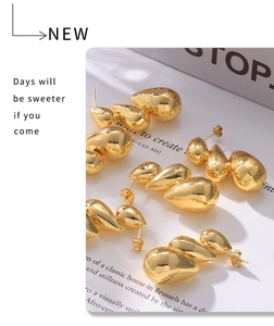 Close-up of golden triple teardrop earrings with high-polish finish on elegant display card